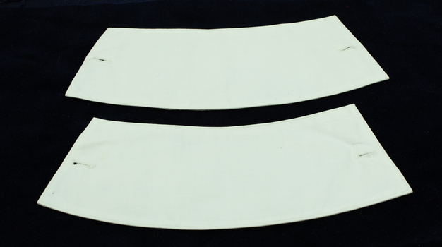 One side of two nurse cuffs showing holes for links