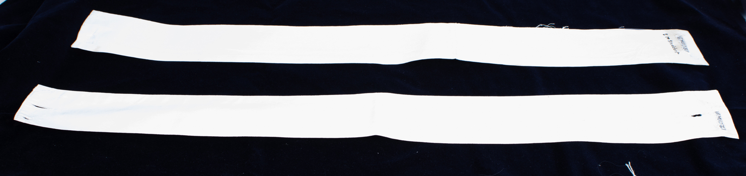 Two nurse belts laid flat with owner's label visible on one.