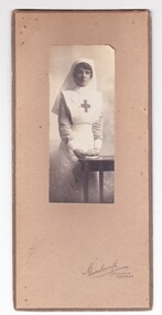 Black and white photographic portrait of nurse mounted in a cardboard frame