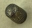 Top of silver thimble showing single daisy-type flower decoration.