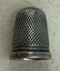 Decorative silver thimble with honeycomb pattern on side.