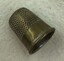 Brass thimble with honeycomb pattern on side and wide plain band around the turned-up rim.