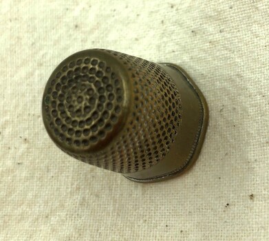 Top view of brass thimble showing spiral pattern.