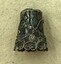 Ornate decorations on the side of silver thimble.