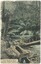 A hand-coloured postcard depicting a creek surrounded by trees and shrubs, with a gold-washing bath in the foreground and a printed caption in the bottom-left.