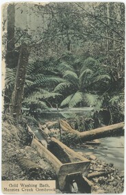 A hand-coloured postcard depicting a creek surrounded by trees and shrubs, with a gold-washing bath in the foreground and a printed caption in the bottom-left.