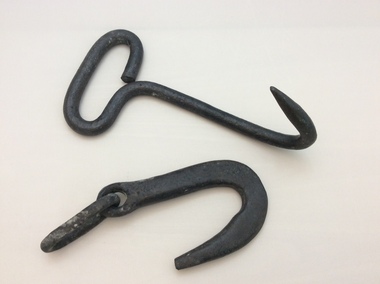 Two iron hooks resting next each other.