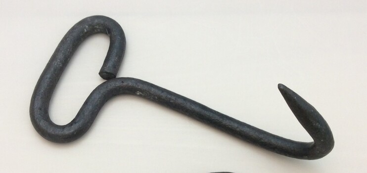 A large iron hook with a handle at the top of its shank.