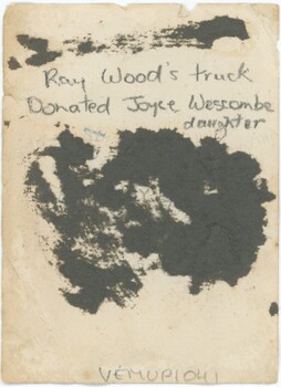 The reverse of a photograph, with handwritten pencil annotation and an accession number.