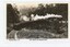 A photocopy of a black and white postcard of a steam train crossing a curving wooden trestle bridge.
