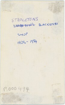 A cream piece of card with handwritten annotation in blue pen and an accession number in pencil.