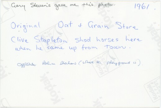The reverse of a printed photograph with handwritten pencil and blue pen annotations.