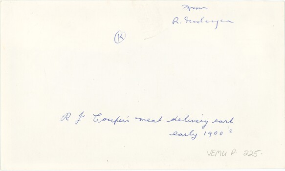 The reverse of a printed photograph with handwritten annotation in blue pen.