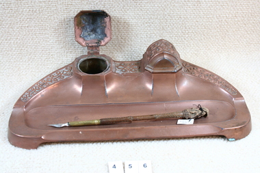 Inkstand with two ink wells and one pen.