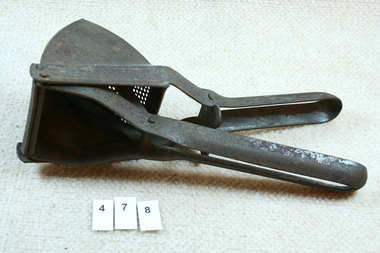 Metal lemon juicer laid flat