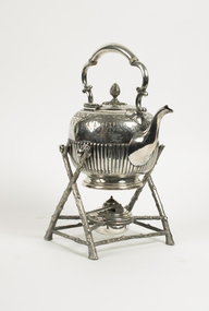 Silver teapot on stand.