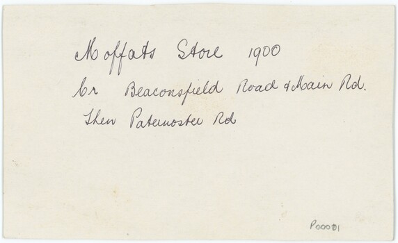 The reverse of a printed photograph, featuring handwritten pen annotation and an accession number.