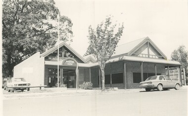 A brick building on the side of a paved road.