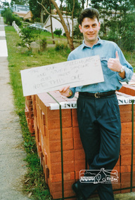 Photograph, Simon Miller holding up a sign protesting at the construction of speed humps, 1991, 1991