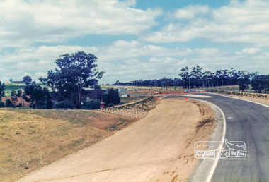 Photograph, Looking east along the newly sealed road from the pedestrian overpass to the new roundabout at Civic Drive; Greensborough Bypass construction, c.1986, 1986c