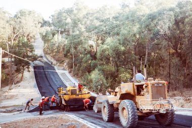 Photograph, Putting on the bitumen, bottom of the 'Big Dipper', road construction, Ryans Road, Eltham North, 1983, 1983