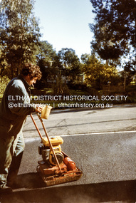Photograph, Compacting bitumen on driveway crossing, road construction, Ryans Road, Eltham North, 1983, 1983