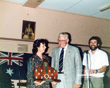 Photograph, Sue Law (Society President) and Russell Yeoman (Society Secretary) (on right) accepting the Major Prize Award from Arthur Freeman(?) for the Society's entry in the Eltham Community Festival Parade, Eltham Senior Citizens' Centre, 8 November, 1986, 08/11/1986
