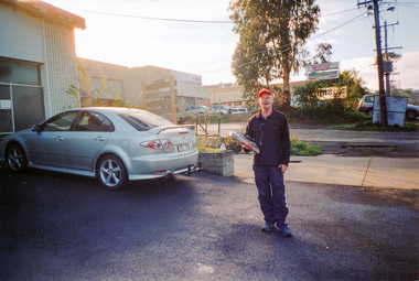 Photograph, Delivery man for 'Diamond Valley Leader' and 'Heidelberg and Diamond Valley Weekly' outside John Cochrane Motors, 23 Peel Street, Eltham, 15 July 2009, 15/07/2009