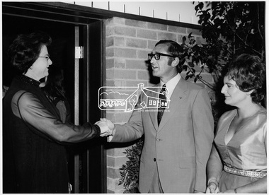 Photograph, Cr. and Mrs. Dreverman greeting a guest at door of West Riding Hall, Henry Petrie Community Centre, on occasion of Buffet Dinner, 7 Jul 1971