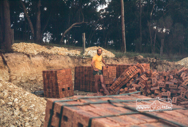 Photograph, Peter Vermey in excavation for garage with with stacks of bricks
