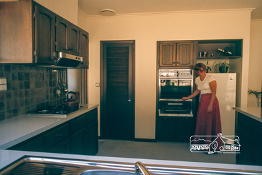 Photograph, Carla Vermey in kitchen from back verandah, April 1980