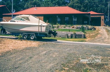 Photograph, Boat parked in front of house, May 1981
