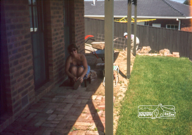 Photograph, Carla Vermey under front verandah cleaning bricks, February 1982
