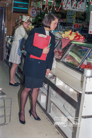 Photograph, Dianne Yans, Health Inspector, inspecting produce in the deiicatessen at Safeway Supermarket, 1989