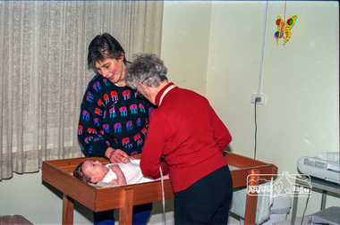 Photograph, Believed to be Sister Alma Brown checking a baby at the Maternal and Child Health Centre, War Memorial Hall, 905 Main Road, Eltham, 1989, 1989
