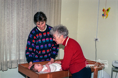 Photograph, Believed to be Sister Alma Brown checking a baby at the Maternal and Child Health Centre, War Memorial Hall, 905 Main Road, Eltham, 1989, 1989