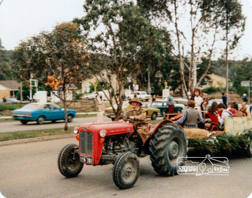 Photograph, Society member Peter Bassett-Smith towing the Shire of Eltham Historical Society float with his tractor in the Eltham Festival Parade along Main Road, 16 October 1982, 16/10/1982