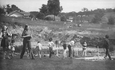Photograph, ELTHAM ARBOR DAY 1973 - Alistair Knox with school children of the Shire of Eltham, Vic, planting native trees in the Town Park, 10 October 1973, 1973-10-10
