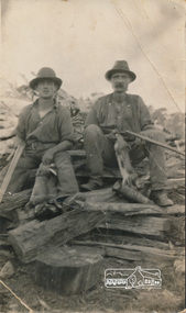 Photograph, Arthur Frederick Castledine (right) sitting on a wood pile towards the rear of their property, Araluen (southern end), Old Eltham Road, Lower Plenty, c.1930, 1930c