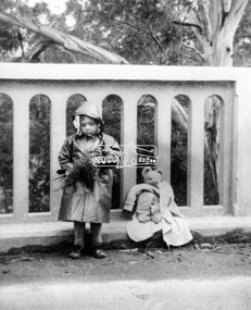 Photograph, Grace Mitchell, A young Jenni Mitchell with flowers and teddy bear on Main Road Bridge, Eltham, 1958c