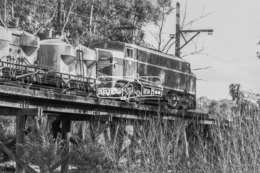 Photograph, George Coop, Victorian Railways electric locomotive L1159 and freight cars traversing the Eltham Railway Trestle bridge, 23 August 1983, 1983