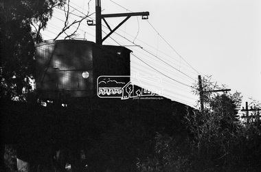 Photograph, A Melbourne bound B Class Diesel-Electric Locomotive silhouetted as it crosses the Eltham Railway Trestle Bridge, c.1983, 1983