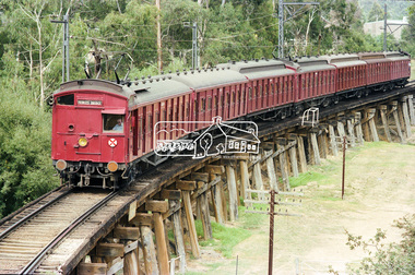 Photograph, George Coop, A Tait (Red Rattler) train passes over the Eltham Trestle Bridge as it heads into Eltham, c. March 1981