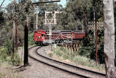 Photograph, A Tait (Red Rattler) train passes over the Eltham Trestle Bridge as it heads into Eltham, c. January 1983, 1983