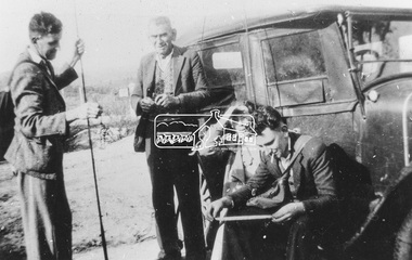 Photograph, Portrait of four men; two standing, one holding a [fishing] pole and two seated on running board of car, c.1925