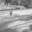 Two young boys stand on a flat dirt block where straight boards have been placed in lines 