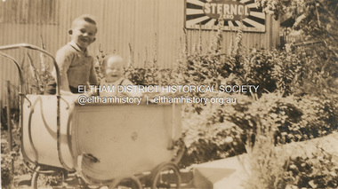 Photograph, Kenneth Albert Ingram and Pam Ingram (in pram) in front of house at Research next to service garage, c.1943
