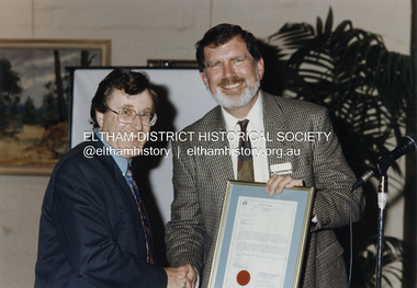 Photograph - Colour Print, Shire of Eltham, Cr. John Graves, Eltham Shire President presents Cr. Bill Penrose with a framed Acknowledgement of Service by Councillors to mark the end of the Shire of Eltham through municipal amalgamation, October 1994