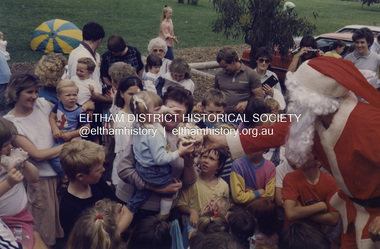 Photograph - Colour Print, Santa Claus assisted by Eltham Shire Council staff handing out Christmas presents to children in Eltham Common, c.1989