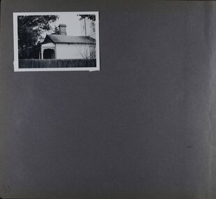 One photo on page - side view of an old house and part of tower taken over a large wooden fence